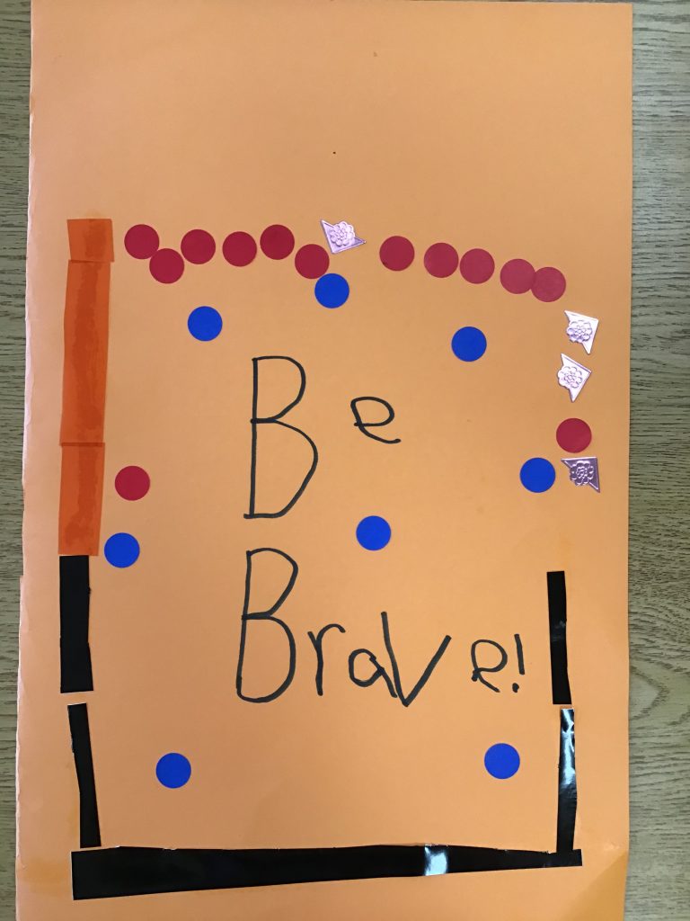 An image of a handwritten sign that reads 'Be brave' with colourful dots and squares surrounding the text